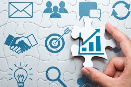 Recommandations individualisées, outils sur-mesure, intelligence artificielle, logiciels gratuits Solutions concrètes pour les PME. Main d'une personne tenant une pièce de puzzle avec un graphique et des icônes de collaboration.