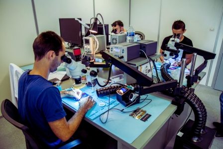 Mars_Conseil_Site_Celandine_Rigoulot Trois personnes travaillant sur des appareils électroniques sous des microscopes dans un laboratoire.