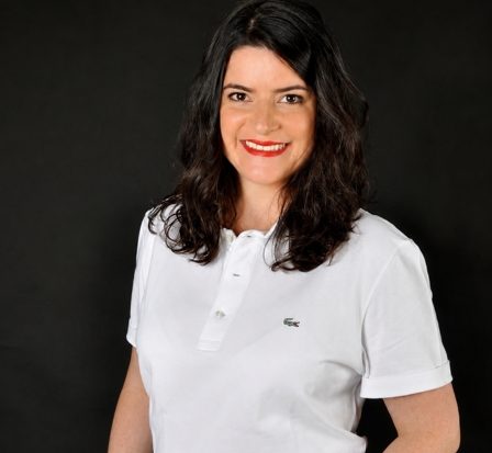 Avocate, cliente souriante en polo blanc sur fond noir.