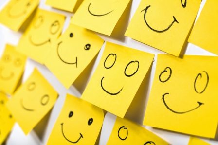 Des petits post-it jaunes avec des visages souriants dessinés.